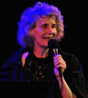 A color photograph of Joanne Brackeen late in her career holding a microphone 🎤.