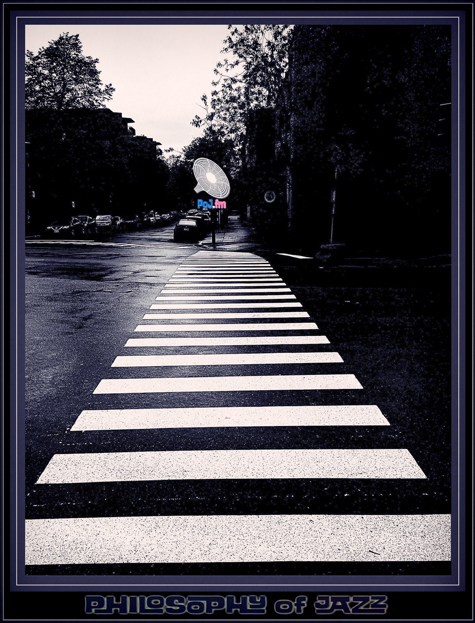 A framed color photograph a wet crosswalk with PoJ.fm logos.