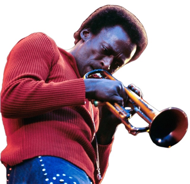 Miles Davis in red sweater and studded blue jeans performing live on stage at the Isle Of Wight Festival 1970 at Afton Down on the Isle of Wight, England on 29th August 1970.
