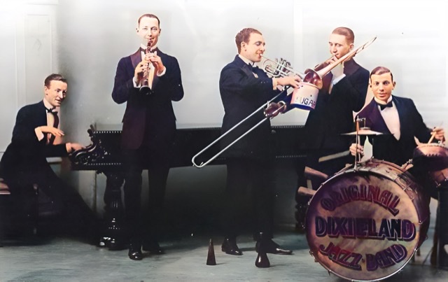 An enhanced and colorized photograph of the five tuxedoed members of the Original Dixieland Jazz Band playing their instruments in an 'action' shot in London in 1919.