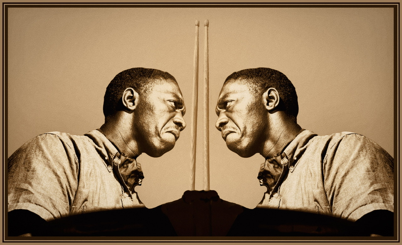 Art Blakey facing himself in a symmetric photograph looking mean with one raised drumstick.