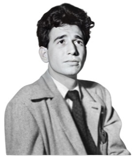 A black and white photograph taken by William P. Gottlieb of Shelly Manne with thick wavy black hair beardless with no glasses in 1946 wearing a seersucker jacket and black knit tie.