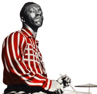 A young Art Blakey with a striped shirt sitting sideways eyes closed facing right playing with brushes.