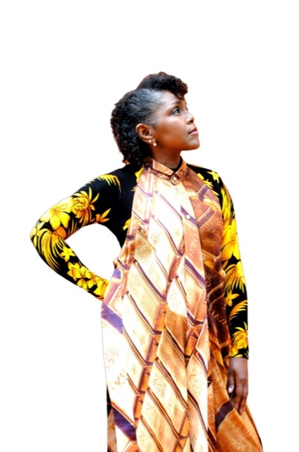 A color photographic cutout of Nubya Garcia in right profile holding her head up with a colorful white dress and yellow and black sleeve.