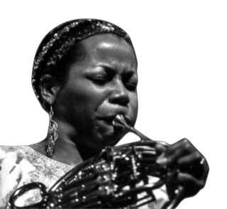 Closeup headshot of Sharon Freeman blowing hard on french horn in 1987 with the George Gruntz Concert Jazz Band, Rockefeller Hall, Houston, Texas.  Photograph by Lindy Pollard.