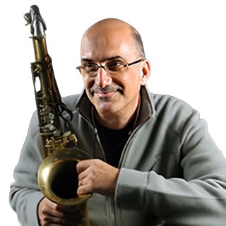 An enhanced and enlarged color photograph of a seated smiling Michael Brecker wearing glasses and holding his saxophone on his right (viewer's left) while wearing a gray unzipped jacket with collar up.