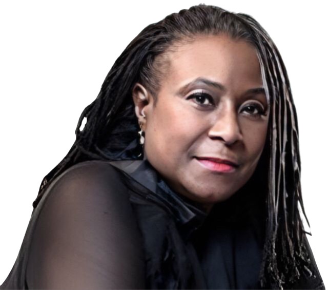 An enhanced color photograph of Geri Allen with dreadlocks in her 50's wearing a black dress sitting at a piano bench turned towards the camera.