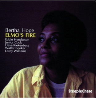 The album cover for "Elmo's Fire" by Bertha Hope-Booker wearing an open yellow shirt displaying her head and shoulders turning slightly to her right on a black background.