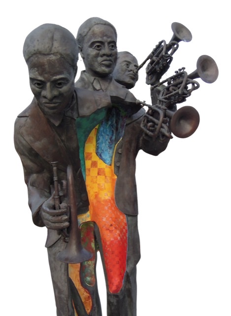 A color photographic cutout of the Buddy Bolden statue with three heads and three trumpets in Louis Armstrong park.