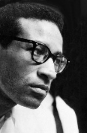 A black and white photograph of a headshot of Max Roach in middle age.