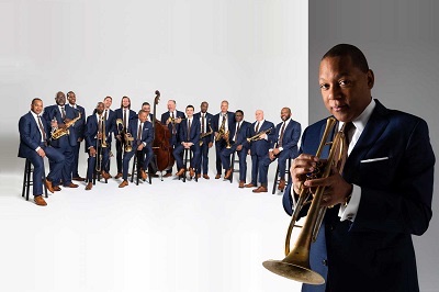A color photograph of Wynton Marsalis front right with the Jazz at Lincoln Center Orchestra in rear at left in 2022.