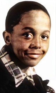 A colorized photograph of a young teenage Charlie Parker headshot smiling.