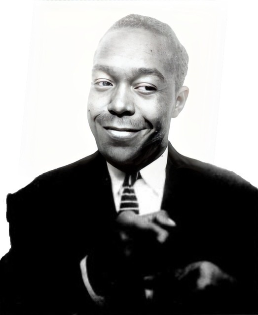 An enhanced photographic cutout of slyly smiling Charlie Parker barely turning his head to the left while he points his right index finger slightly toward his left as if pointing at something.