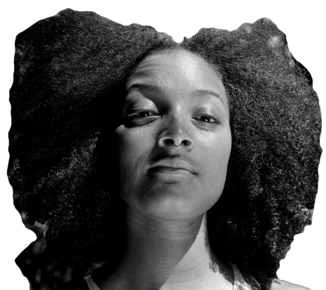 A black and white photograph headshot of Nubya Garcia looking straight at viewer wearing a large Afro haircut bent on left and right sides at center of her head.