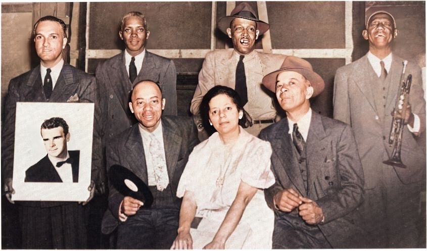 A colorized photograph of Bertha Gonsoulin in center surrounded by the Bunk Johnson band with Bunk on the far right.